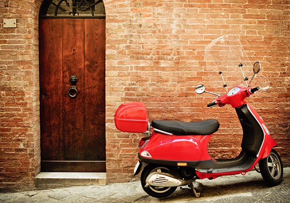 Vintage image of red scooter on the street of Italy